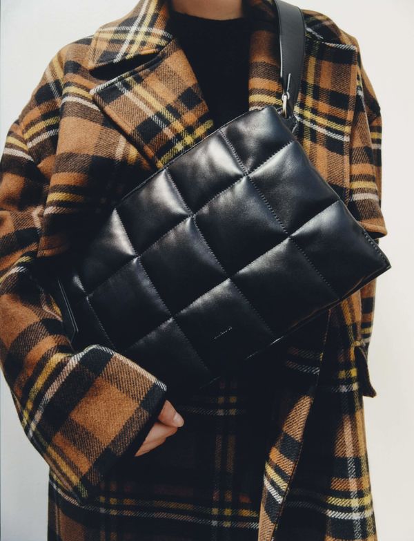 Close up shot of a model wearing Allsaints's leather shoulder bag.