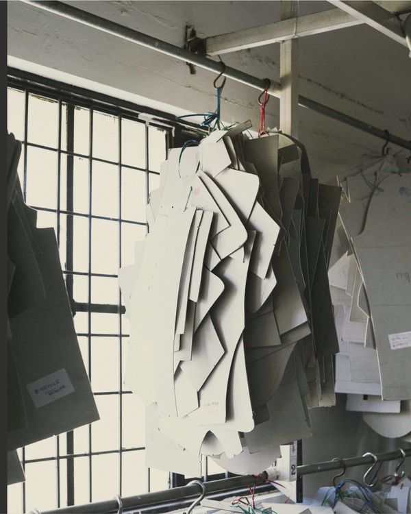 Fit cardboards are hanging on a rail in a warehouse.