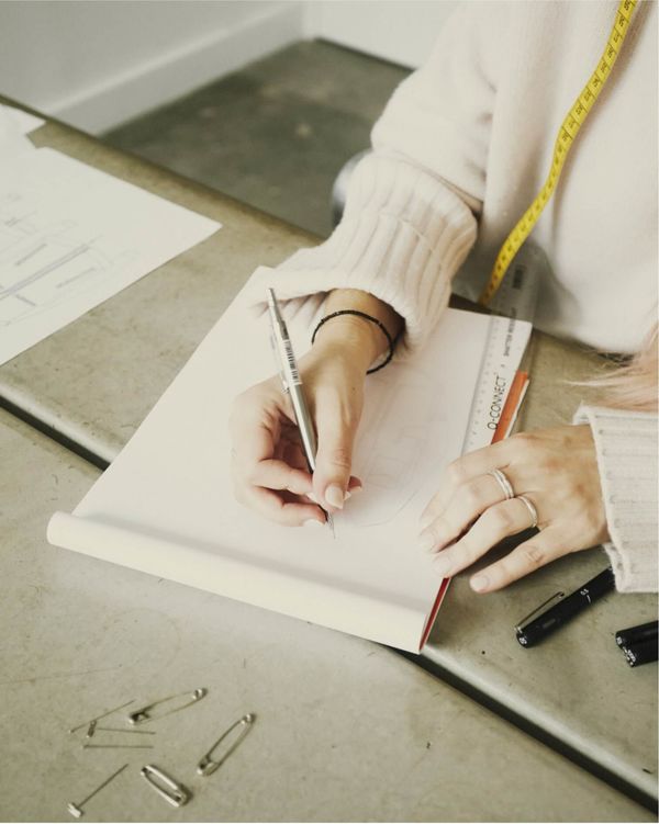  A woman is drawaing a sketch of leather jacket.