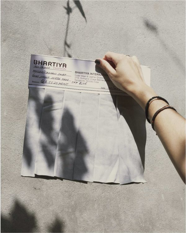 A woman is holding a grey sample of suede leather.