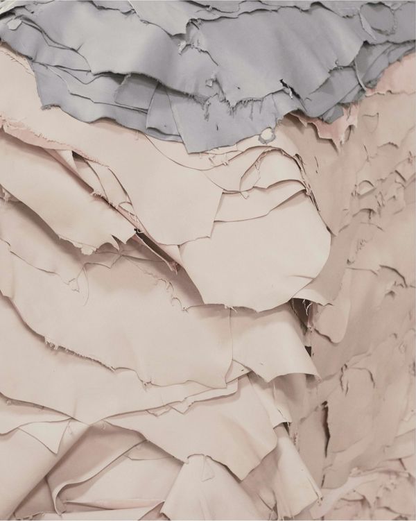 Pile of grey leather pieces and pink leather pieces.