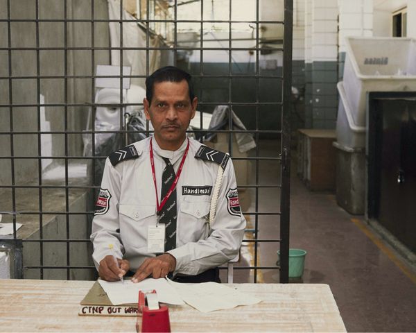 A man is facing the camera while filling a quality check form. 