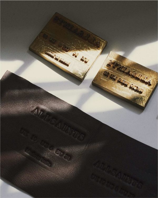 Close up on our leather label next to our embossment stamps.