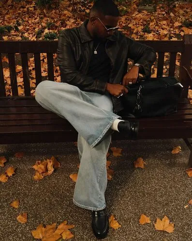 Man sitting on bench around leaves