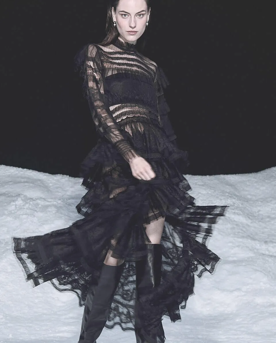Women in black dress stood in front of snow