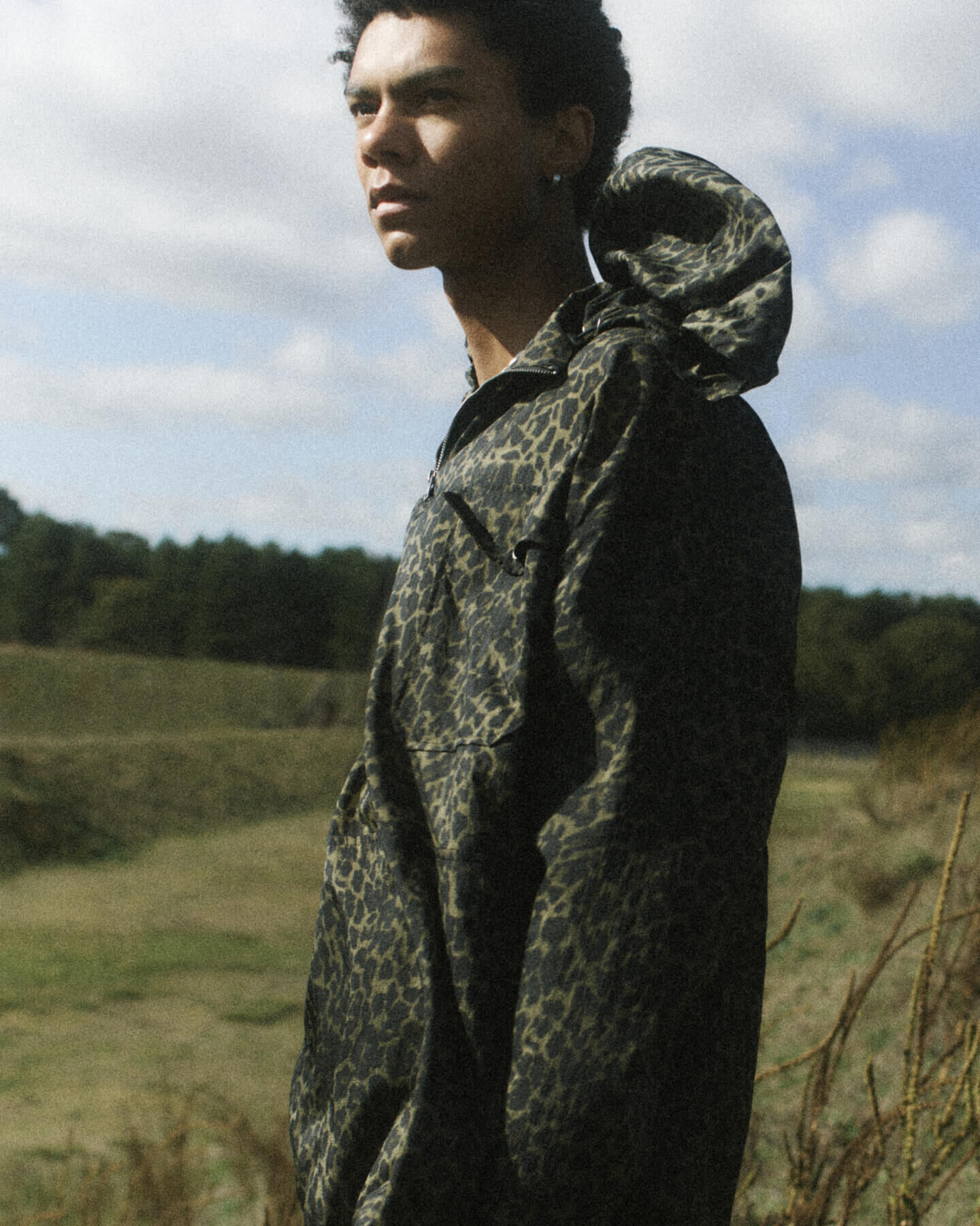 Man wearing green leopard print hoody in a field
