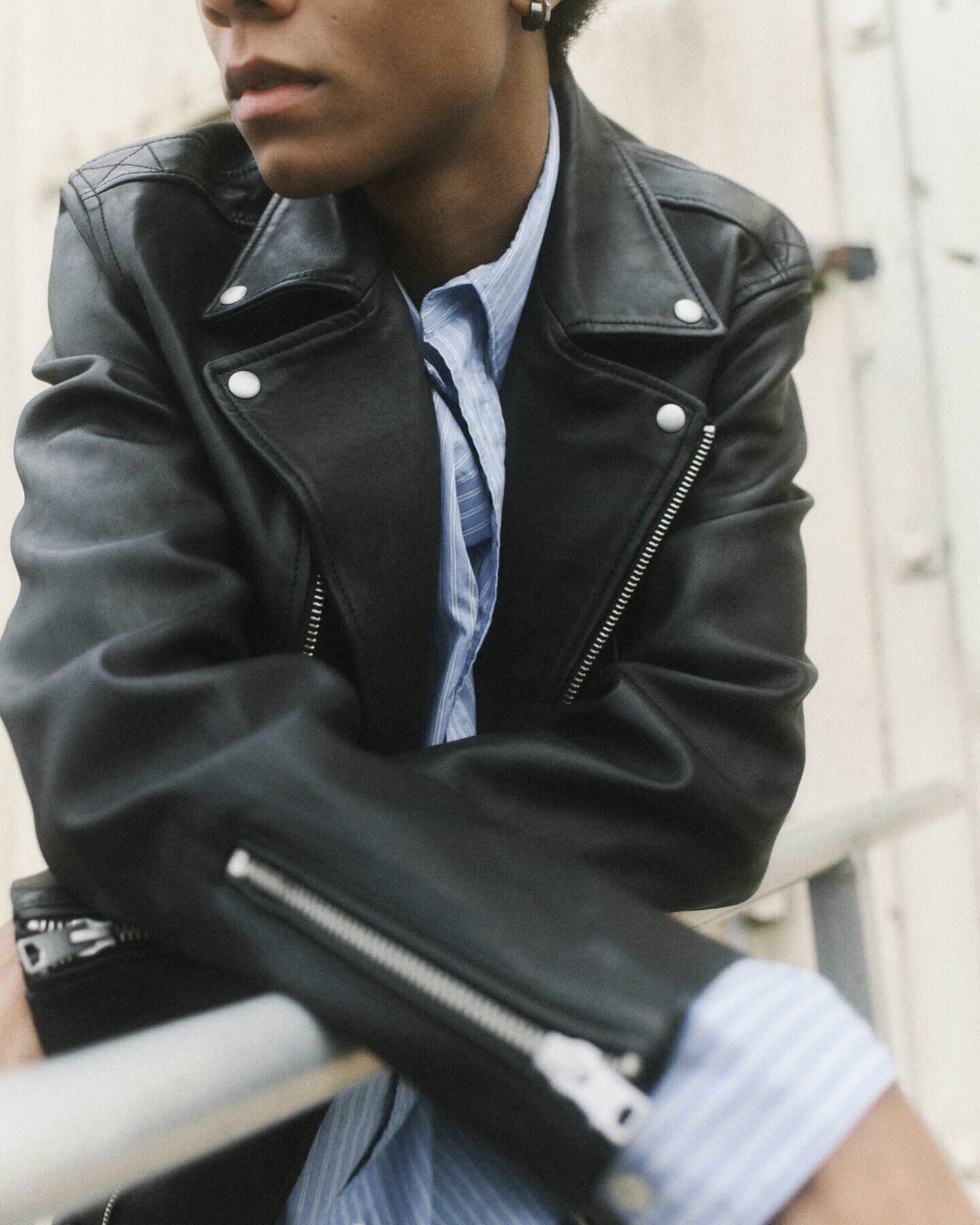 Man wearing a black leather jacket and blue shirt
