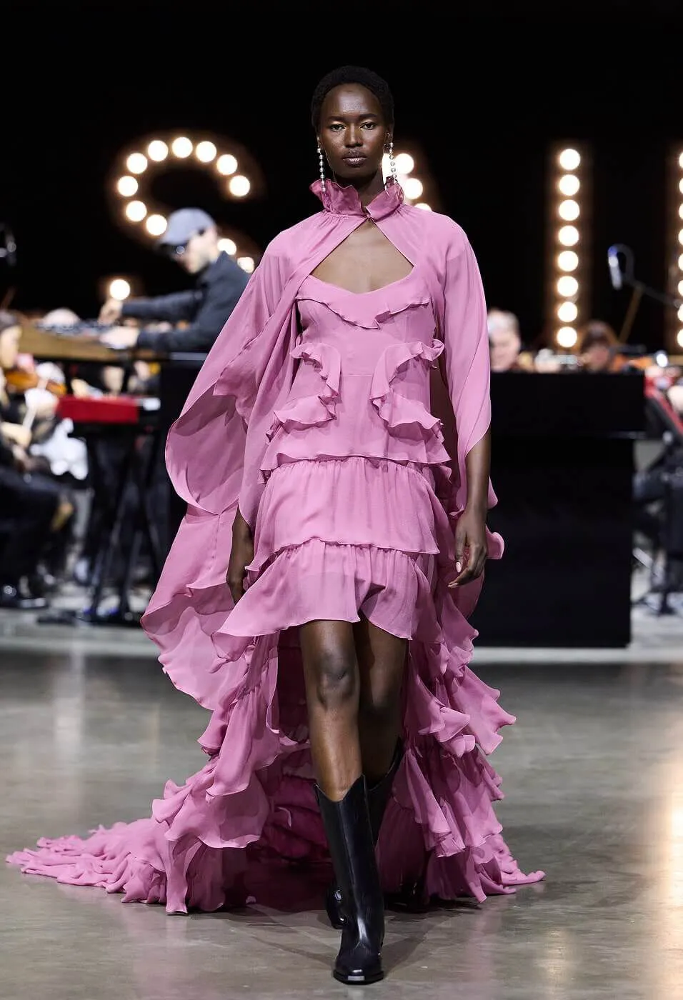 Woman wearing a flowy pink dress with black leather boots