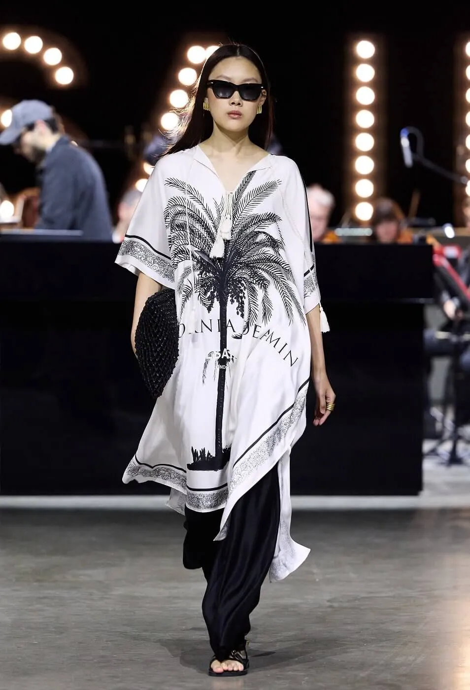 Women wearing palm tree printed throwover with black sunglasses and black trouser