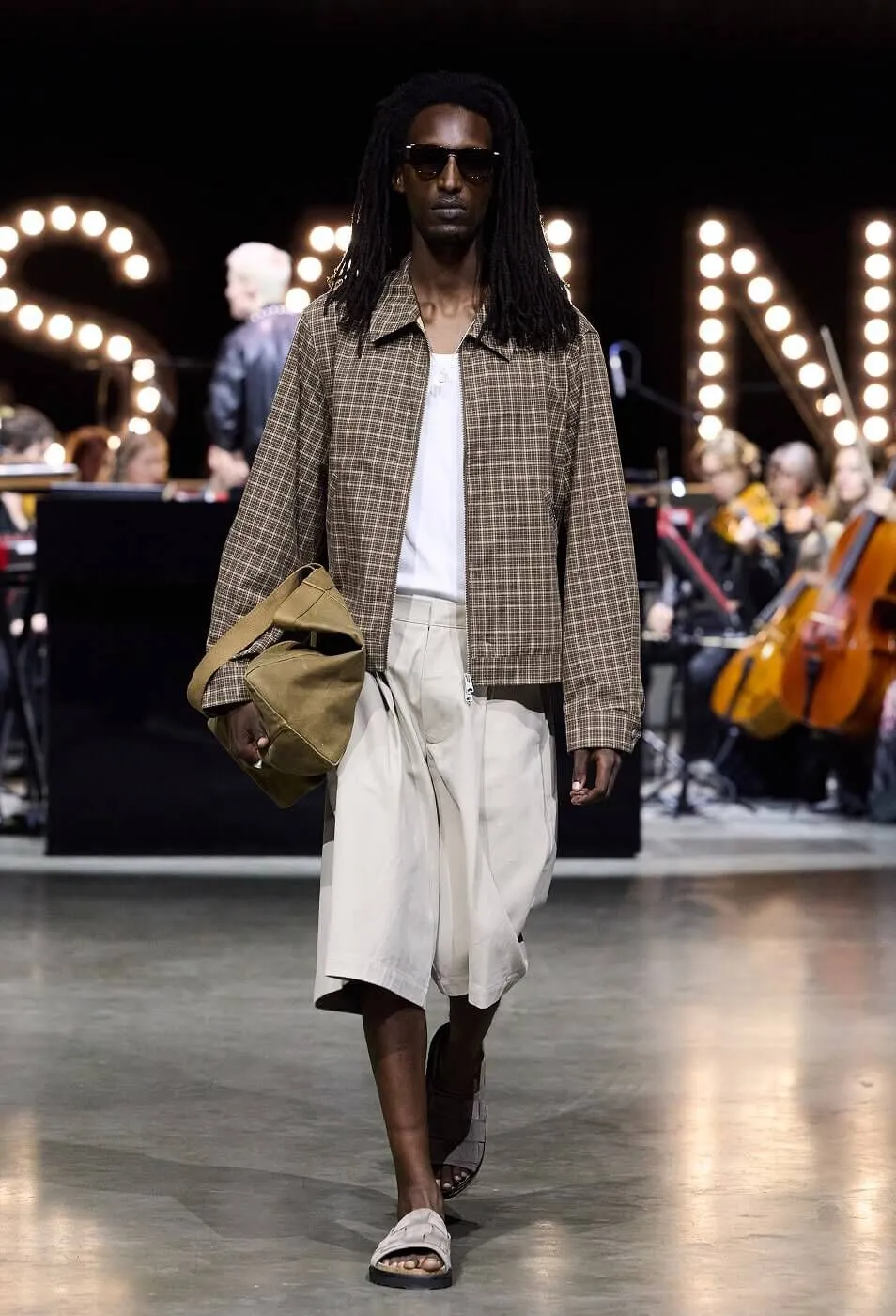 Man wearing checkered jacket with white t-shirt and beige shorts