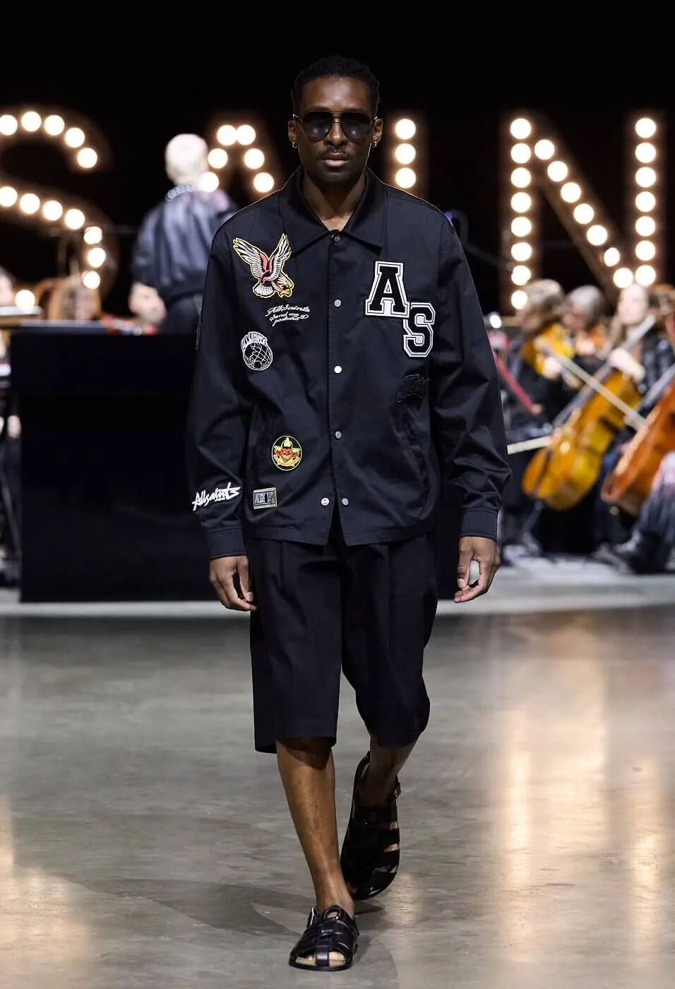 Man wearing black leatherman jacket with black shorts