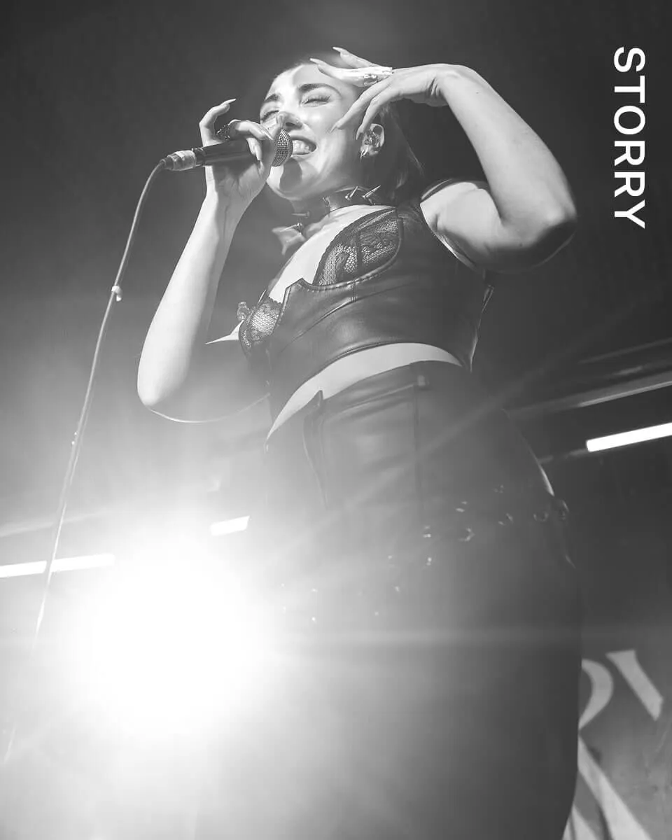 Black and white shot of STORRY on stage performing.