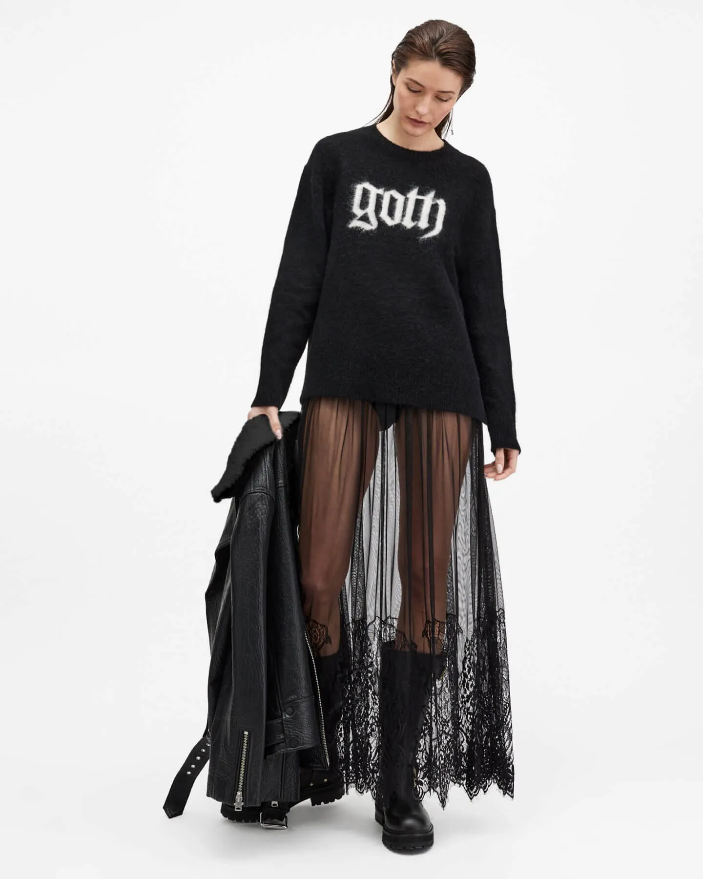 Woman wearing a black jumper and transparent skirt.