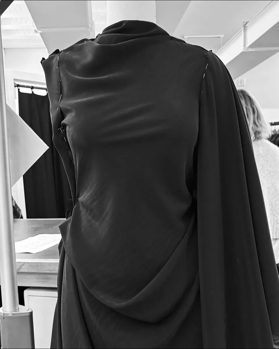 Image of a work in progress black garment on a mannequin